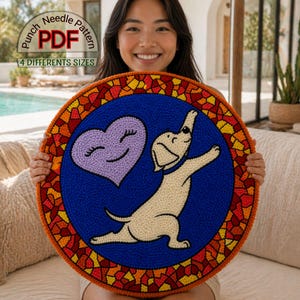 Puede incluir: Un patrón circular de aguja mágica con un perro beige claro y un corazón morado sobre un fondo azul. El diseño está enmarcado por un borde de mosaico en tonos naranja, amarillo y rojo. El texto dice "Punch Needle PDF Pattern" y "4 Different Sizes".