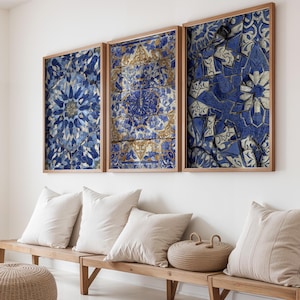 Puede incluir: Tres obras de arte enmarcadas con intrincados diseños de azulejos azules y dorados. La obra de arte se exhibe sobre un banco de madera con almohadas blancas y una cesta tejida. Los marcos son de madera clara, complementando la paleta de colores neutros de la habitación.