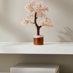 Handmade rose quartz crystal tree of life with pink gemstone leaves for love and healing.