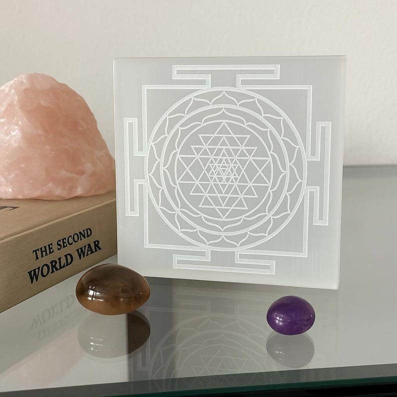 "Hand carved selenite charging plate with a laser-engraved Shri Yantra for crystal healing."