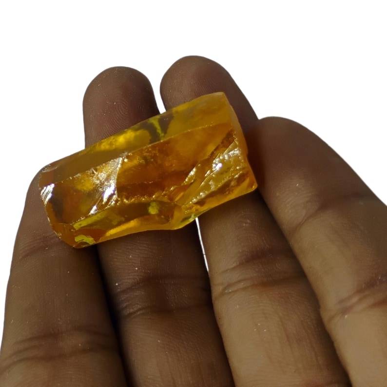 Yellow sapphire healing crystal in sunlight highlighting natural inclusions