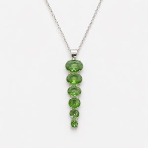 Handmade green peridot style pendant necklace in sterling silver featuring oval cut gemstones in vertical drop design, August birthstone statement jewelry.