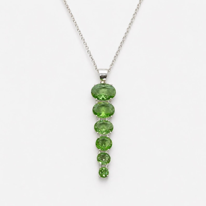 Handmade green peridot style pendant necklace in sterling silver featuring oval cut gemstones in vertical drop design, August birthstone statement jewelry.