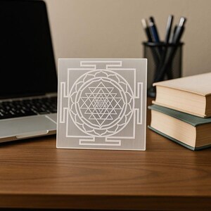 "White selenite plate with Shri Yantra, used for amplifying energy and spiritual practices."