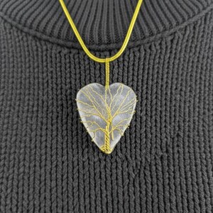 Artisan wire-wrapped moonstone heart pendant, highlighting the natural stone and gold tone details.
