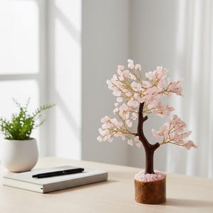 Close-up of delicate pink rose quartz chips blossoming on copper wire branches.