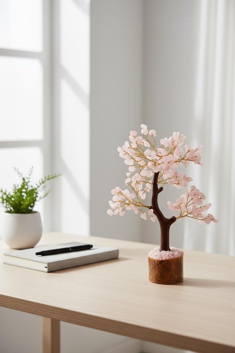 Close-up of delicate pink rose quartz chips blossoming on copper wire branches.
