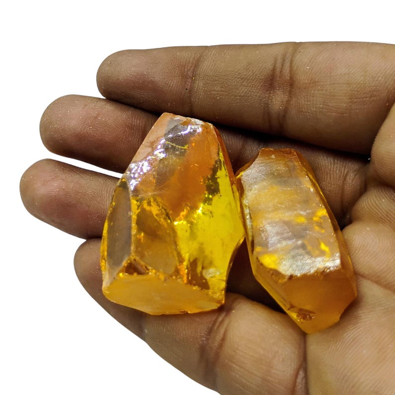 Golden yellow sapphire rough stone with metallic ruler scale