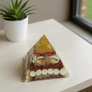 “close up of cowrie shells and gomti chakra coins in orgone pyramid”