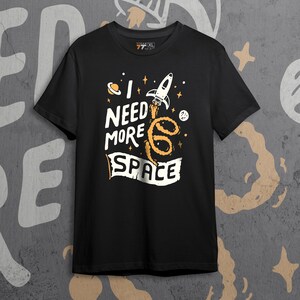 Camiseta unisex "Necesito más espacio" / Divertida camiseta negra de algodón con arte de astronauta / Idea de regalo para amantes de la galaxia / Estilo urbano de ciencia ficción espacial