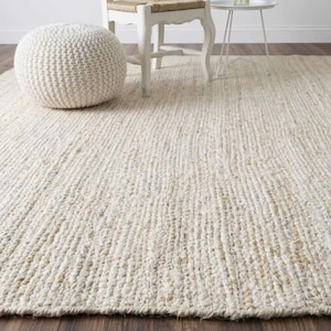 May include: A large, rectangular, off-white area rug with a thick, braided, and textured weave. The rug features a natural, light beige and cream colour palette, covering the floor space with a consistent, heavy-duty, woven fibre construction.