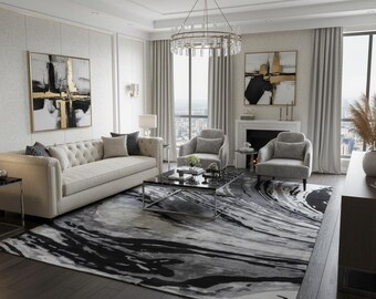 May include: An elegant living room with a beige sofa, two grey armchairs, and a black marble coffee table. The room features a large rug with a black and grey abstract design, artwork, and a chandelier.