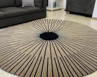 May include: A round beige rug with a black circular center and radiating black lines. The rug is on a tiled floor. The words "CUSTOM RUGS DESIGN" are printed on the bottom right.