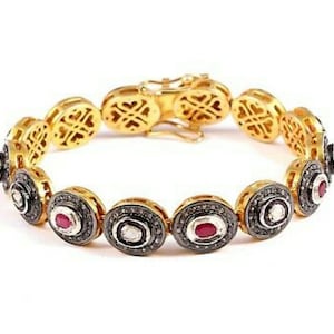 May include: Gold bracelet with oval links, each set with a ruby and diamond. The bracelet has a decorative clasp and is intricately detailed, showcasing a luxurious aesthetic. The bracelet is approximately 18 cm in length.