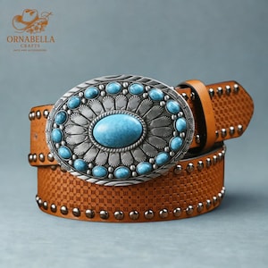 May include: A brown leather belt with a large, oval silver buckle. The buckle features a large turquoise stone in the center, surrounded by smaller turquoise stones and a decorative silver design. The belt is studded with silver rivets.