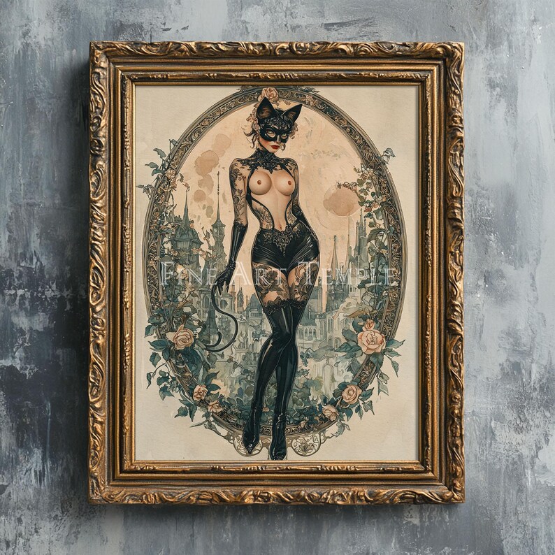 May include: A framed vintage-style print featuring a woman in a cat mask and lingerie, holding a whip. The artwork is set within an oval frame surrounded by roses and a cityscape background. The frame is gold-colored.