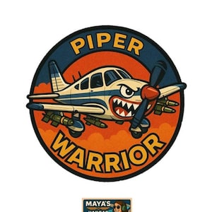 May include: A circular patch featuring a cartoon airplane with a menacing grin, labeled "Piper Warrior." The plane is blue and white, set against an orange and blue background. A smaller rectangular graphic at the bottom reads "Maya's Hangar."