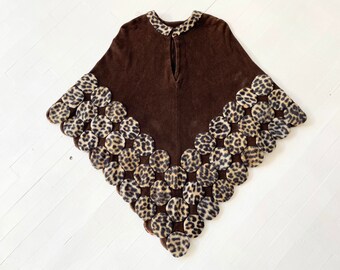 Könnte beinhalten: Ein braunes Poncho mit einem Leopardenmuster-Besatz. Der Besatz besteht aus zusammengenähten Stoffkreisen.