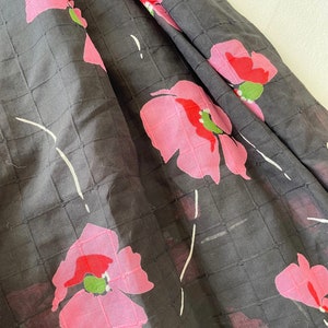 Peut inclure: Tissu noir avec un motif quadrill&eacute; et un imprim&eacute; floral rose. Les fleurs ont des centres rouges et des feuilles vertes.