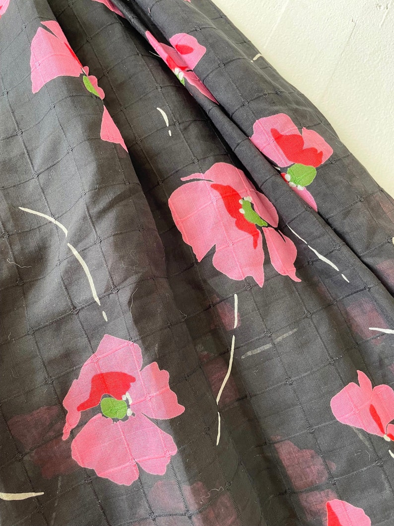 Peut inclure: Tissu noir avec un motif quadrill&eacute; et un imprim&eacute; floral rose. Les fleurs ont des centres rouges et des feuilles vertes.