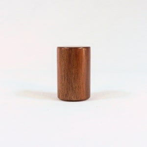 May include: A cylindrical wooden knob with a rich brown color and a wood grain pattern.