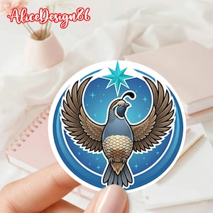 Op de afbeelding: Een ronde sticker met een gestileerde kwartel met uitgespreide vleugels, tegen een blauwe sterrenachtergrond. De kwartel is afgebeeld in tinten grijs, bruin en blauw, met een ster boven zijn hoofd. De sticker heeft een blauwe rand.