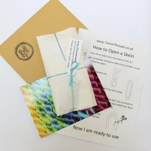 May include: A craft package containing a skein of yarn wrapped in paper and tied with teal string. The package includes a brown envelope with a logo and instructions on how to open the skein, with the website address www.TamarThreads.co.uk.