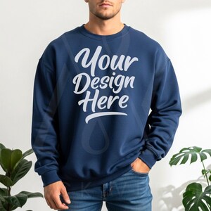 Navy blue crewneck sweatshirt with long sleeves and relaxed fit, paired with blue jeans in bright natural light—optimized for POD sellers and creative Etsy stores.