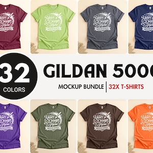May include: A mockup bundle of Gildan 5000 t-shirts in various colors, including burgundy, green, gray, and navy. Each shirt features the text "Your Design Here" in a decorative font. The image also displays the text "32 Colors" and "32X T-Shirts".