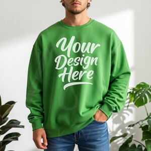 Green crewneck sweatshirt with long sleeves and relaxed fit, styled with blue jeans in natural light—perfect for Printify and Etsy POD sellers.