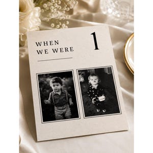 Close-up of an editable When We Were wedding photo table number template with premium minimalist typography, childhood photo display, old money wedding decor, printable Canva wedding table sign and elegant reception centerpiece.