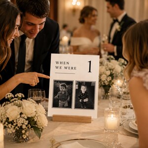 Wedding guests enjoying a When We Were childhood photo table number at a reception. Editable Canva wedding photo sign, sentimental wedding table decor, old money centerpiece template and printable reception table number.
