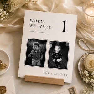 Flat lay of a When We Were wedding photo table number template with luxury wedding stationery styling. Editable Canva childhood photo table sign, minimalist old money wedding decor and printable reception centerpiece.