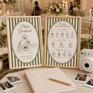 May include: Two gold-framed signs with olive green stripes and oval centers. One sign reads Photo Guestbook, Olivia & James, 03.11.2027. The other sign provides Camera Instructions. A white instant camera, a guestbook, and a gold pen are included.
