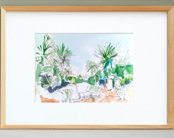 May include: Watercolor painting of a tropical garden scene, framed in a light wood frame. The artwork features lush green plants, palm trees, and a light blue sky. The painting is a sketch-like style.