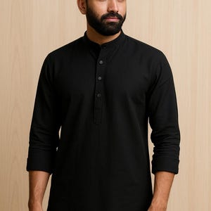 May include: Black long-sleeve shirt with a mandarin collar and a button-down placket. The shirt has a relaxed fit and is made of a soft, solid-colored fabric. The sleeves are rolled up to the elbows. The shirt is suitable for casual wear.
