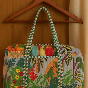 Puede incluir: Un bolso tote acolchado y colorido con un diseño vibrante. El bolso presenta un asa a rayas verdes y blancas y una ilustración detallada de una mujer en un jardín. El bolso está colgado de una percha de madera.