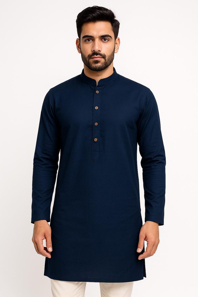 May include: Dark navy blue long-sleeved tunic with a mandarin collar and button-down front. The tunic has a straight hem and is made of a solid, dark blue fabric. The buttons are light brown.