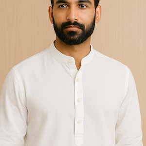 Pu&ograve; includere: Una camicia bianca a maniche lunghe con colletto alla coreana e chiusura con bottoni. La camicia ha un design semplice e minimalista, con una vestibilit&agrave; su misura. Le maniche sono arrotolate ai polsi. Realizzata in tessuto leggero.