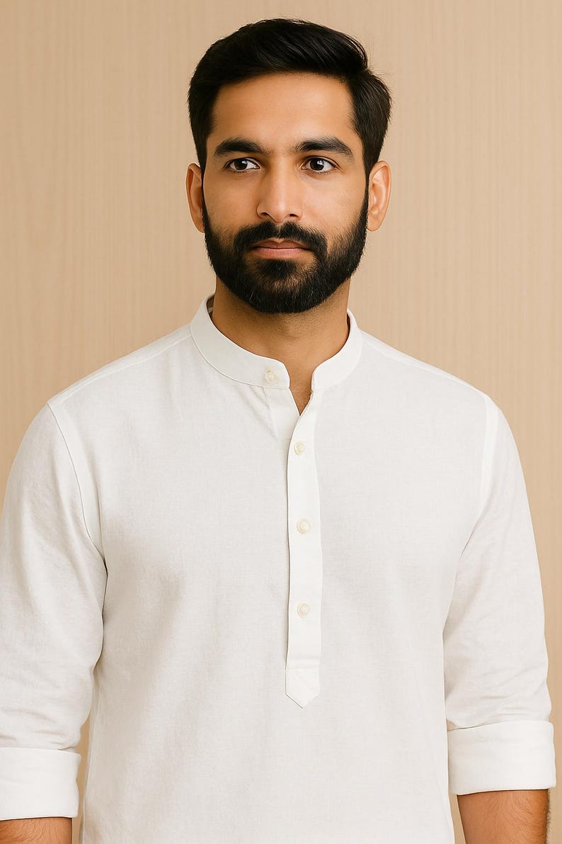 Pu&ograve; includere: Una camicia bianca a maniche lunghe con colletto alla coreana e chiusura con bottoni. La camicia ha un design semplice e minimalista, con una vestibilit&agrave; su misura. Le maniche sono arrotolate ai polsi. Realizzata in tessuto leggero.