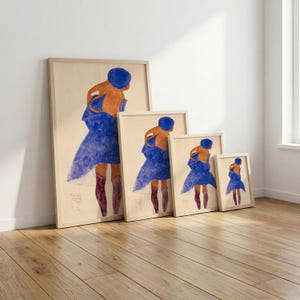 May include: A set of four framed art prints featuring a figure in a blue dress and hat, with orange skin and burgundy boots. The prints are displayed in a row, each a different size, with a light wood frame.