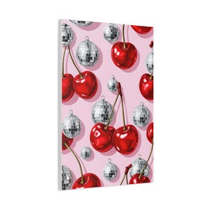 May include: A canvas print with a repeating pattern of vibrant red cherries and silver disco balls against a pale pink backdrop. The cherries have green stalks, and the disco balls are spherical with a reflective surface. The artwork has a retro, playful feel.
