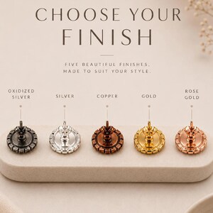 May include: Five circular earring backs with notched edges, displayed in oxidized silver, silver, copper, gold, and rose gold finishes. Text reads: CHOOSE YOUR FINISH, FIVE BEAUTIFUL FINISHES, MADE TO SUIT YOUR STYLE, ILONA RUBIN Atelier-made jewelry.