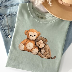 パンチベイビーモンキーシャツ、感情を揺さぶるぬいぐるみモンキーTシャツ、孤独なモンキーグラフィックTシャツ、バイラルサッドモンキーシャツ、感情を揺さぶる慰めの動物