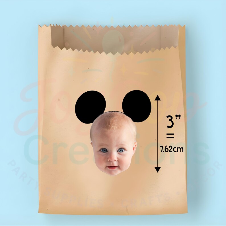 May include: A brown paper bag featuring two black circles and a baby's face. The bag has a 3-inch (7.62 cm) measurement indicator.