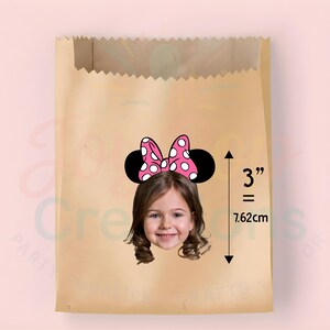 May include: A brown paper bag featuring a Minnie Mouse headband graphic. The headband has a pink bow with white polka dots and black ears. The graphic is 7.62cm in height.