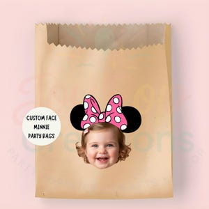 May include: A brown paper party bag featuring a Minnie Mouse design. The design includes a pink bow with white polka dots, black mouse ears, and a child's face. Text on the bag reads "CUSTOM FACE MINNIE PARTY BAGS."