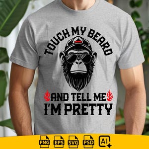 Puede incluir: Camiseta gris claro con un diseño de un mono con gafas de sol y gorra, con el texto "TOUCH MY BEARD AND TELL ME I'M PRETTY" en negro. Dos llamas rojas a cada lado del texto.