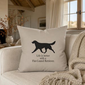 Könnte beinhalten: Ein quadratisches beiges Zierkissen mit einer schwarzen Silhouette eines Flat-Coated Retrievers in der Mitte. Unter der Hunde-Grafik steht der Text: Life is better with a Flat-Coated Retriever. Das Kissen hat einen glatten, einfarbigen Bezug.