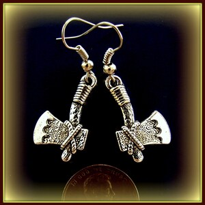 May include: Silver tone axe head earrings with a rope design. The earrings are hanging from silver tone hooks.